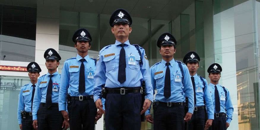 A line of security guards in blue uniforms