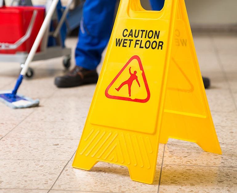 Wet floor sign and cleaning in progress